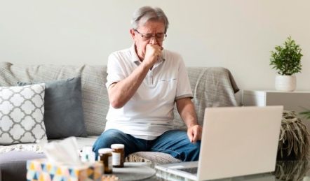 un hombre tose a causa de un cáncer de pulmón