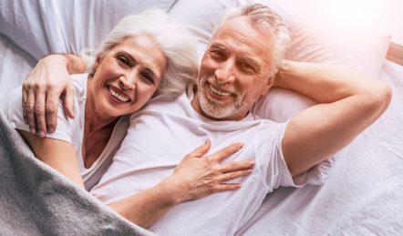 ein glückliches älteres Paar, das auf einer bequemen Matratze schläft