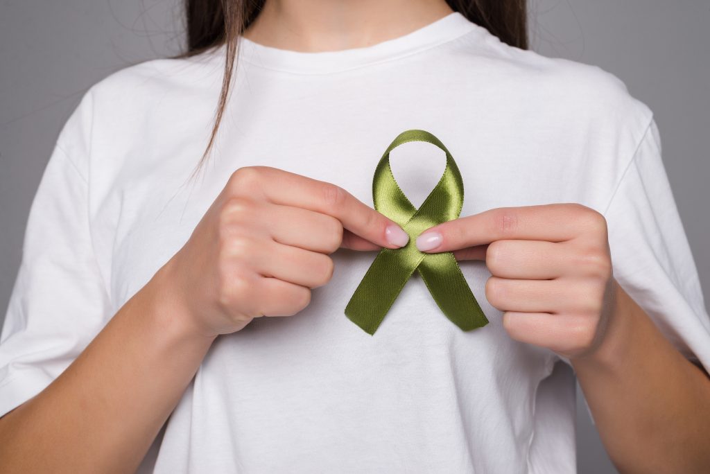 woman holding a green ribbon for kidney cancer