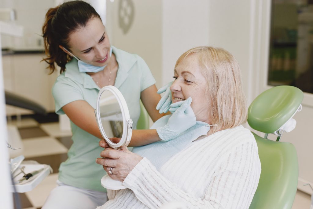 dentist checking a woman's teeth aligner