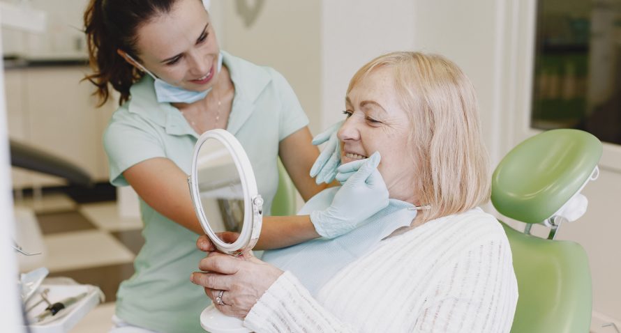 dentist looking at a woman's teeth aligners