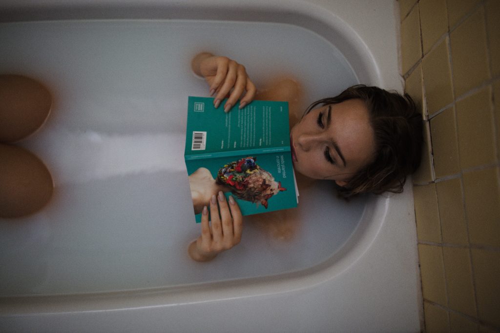 woman reads a book in a walk-in tub