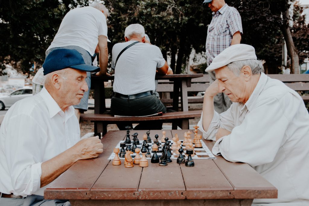 happy seniors playing chess in an assisted living facility